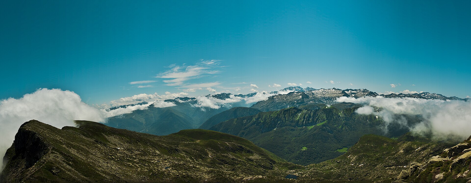 Crête herbeuse et rocheuse menant au sommet du pic des Trois Seigneurs, avec les hauts sommets ariégeois à l'arrière-plan